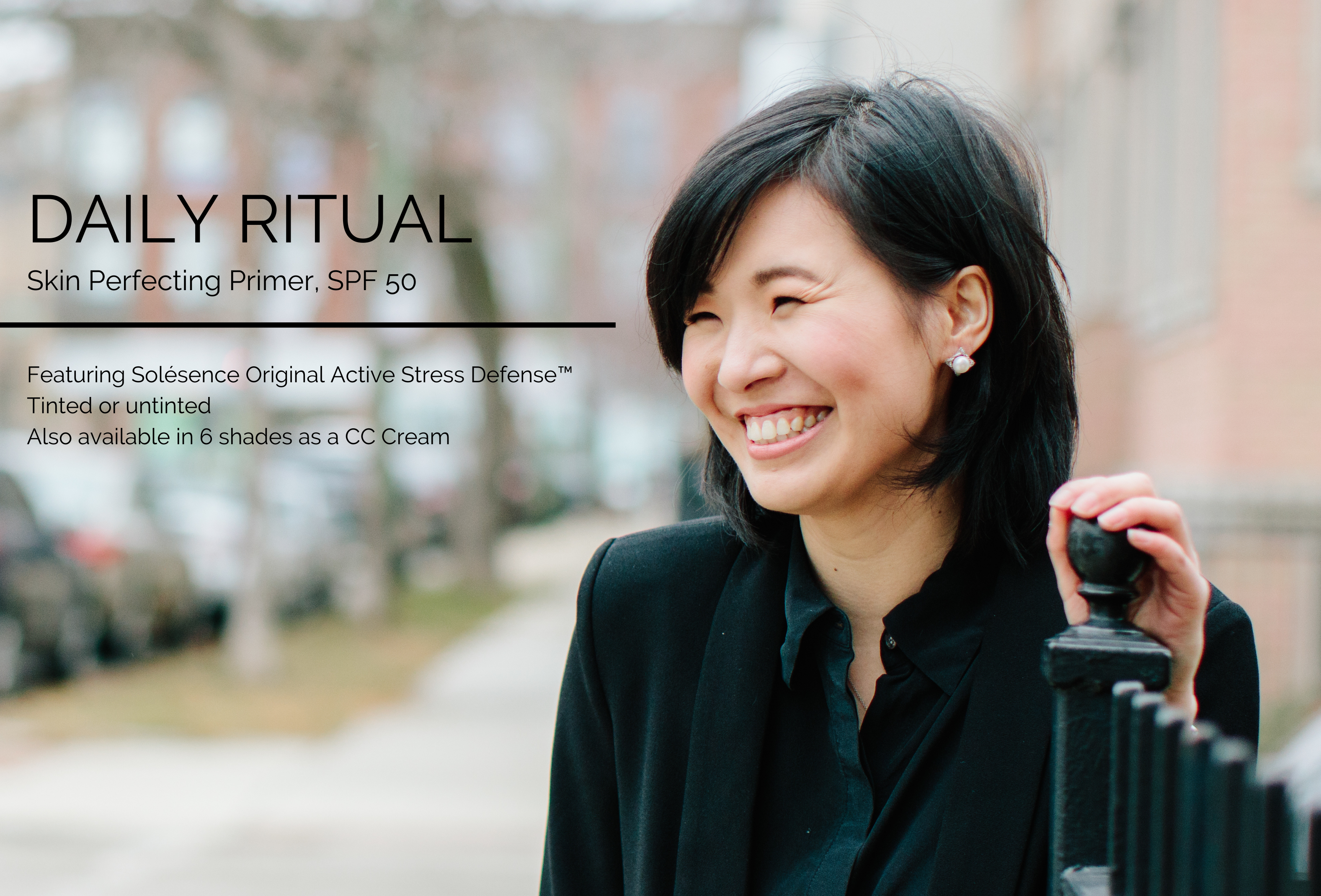 Woman in black work attire smiling, standing outside on the sidewalk