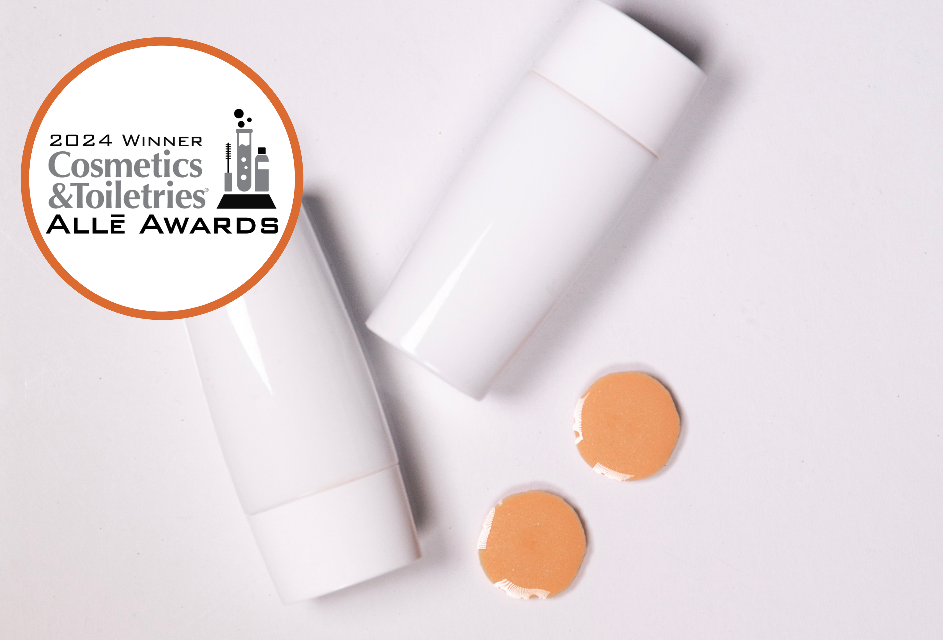 A bottle of makeup with two dots of makeup next to it