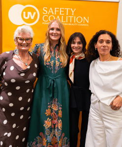 Four women stand in front of a backdrop.
