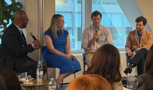 Four people on chairs, holding microphones and talking.